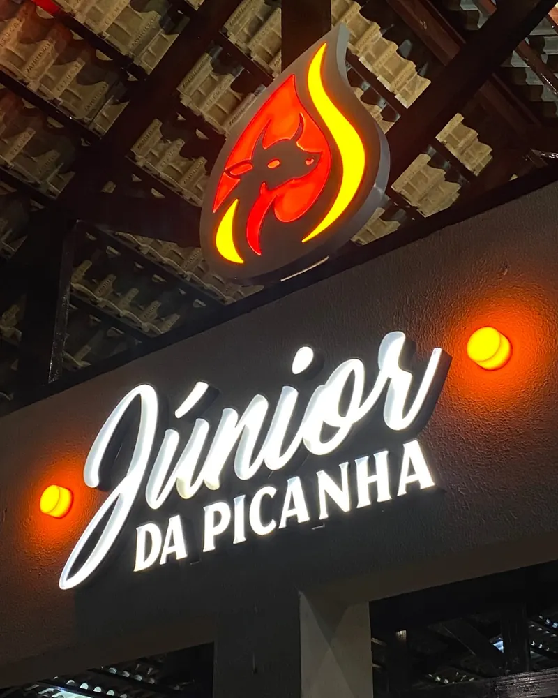 Letreiro iluminado do Júnior da Picanha à noite